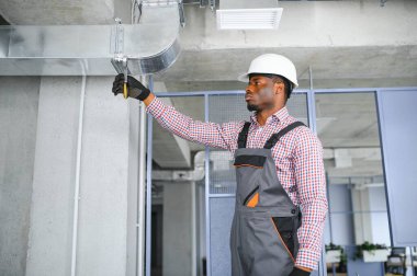 HVC işçisi havalandırma ve havalandırma için boru sistemi kuruyor. Boşluğu kopyala