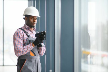 Tulum pencere yüklerken bir genç Afrika tamirci düşük açılı görünümü.