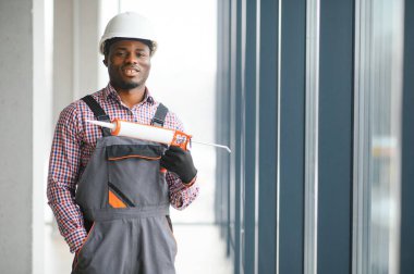 Evdeki oturma odasına plastik pencereler monte eden ya da ayarlayan işçi