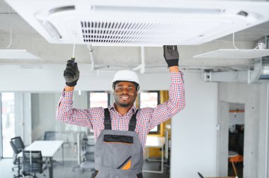 Profesyonel bir tamirci odaya klima kuruyor..