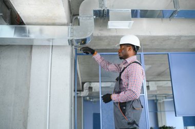 HVC işçisi havalandırma ve havalandırma için boru sistemi kuruyor. Boşluğu kopyala