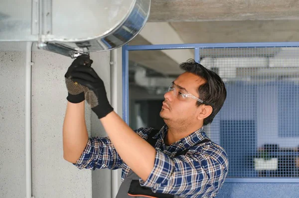 Ventilation cleaning. Specialist at work. Repair ventilation system (HVAC). Industrial background.