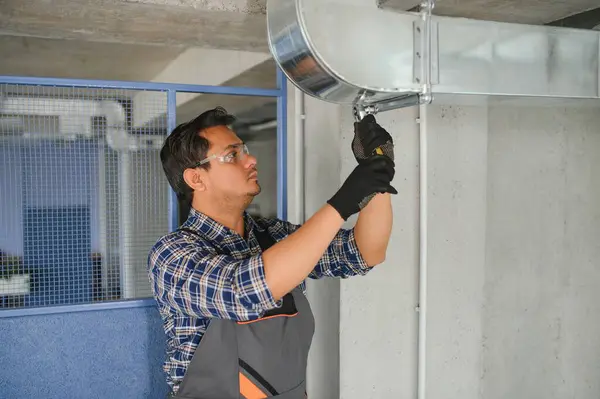 Ventilation cleaning. Specialist at work. Repair ventilation system (HVAC). Industrial background.