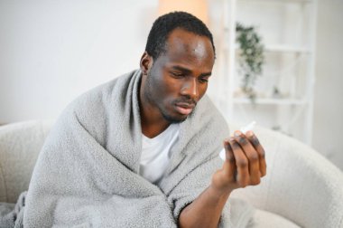 burun spreyi ile sıcak fularlı hastalıklı bir Afrikalı-Amerikalı adam.