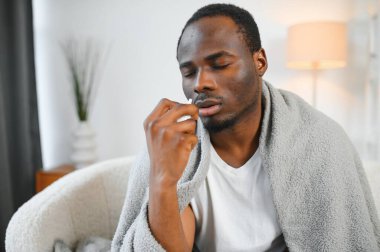 burun spreyi ile sıcak fularlı hastalıklı bir Afrikalı-Amerikalı adam.