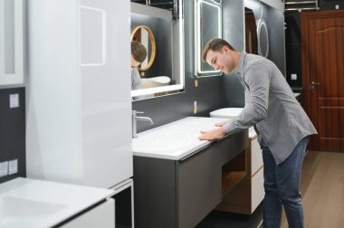 Satıcıyla lavabo seçen adam..