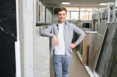 Markette fayans seçen genç bir adam.