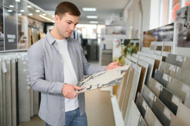 Adam duvar karoları tuvalet sırası süpermarkette yapı malzemeleri seçer.