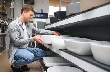Satıcıyla lavabo seçen adam..