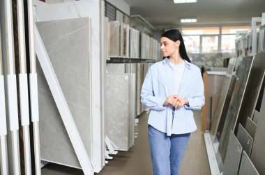 Kadın iç mimar dükkândan döşeme rengi doku örnekleri seçiyor..