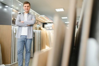 Erkek mimar ya da iç mimar tasarım stüdyosundan seramik doku örneği seçiyor. Mimarlık ve inşaat endüstrisi için zemin ve duvar bitiş materyali.