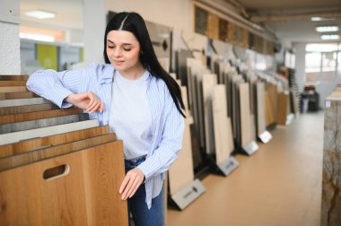 Evini yenilemek için katın kaplamasını seçen genç kadın..