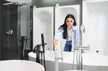 Banyoda banyo yapmayı seçen bir kadın, inşaat malzemeleri..