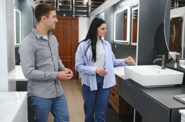 Banyodaki mobilya dükkanında lavaboyu seçen pozitif çift..