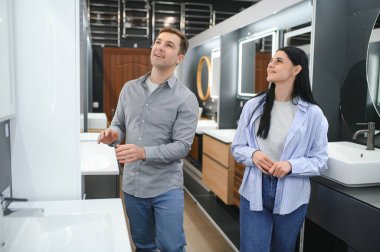 Banyodaki mobilya dükkanında lavaboyu seçen pozitif çift..