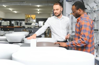 Dükkanda satıcı ile Afrikalı müşteri var..