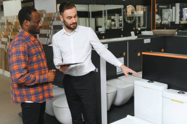 Dükkanda satıcı ile Afrikalı müşteri var..