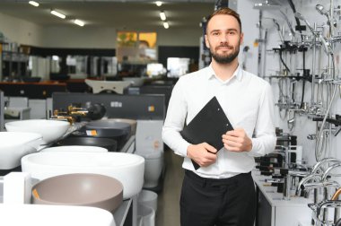 Tesisatçı dükkanında kağıt tabletli mutlu bir satıcı..