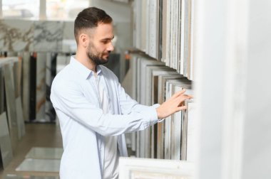 Adam ev banyosu için seramik fayans ve kap kacak seçiyor..