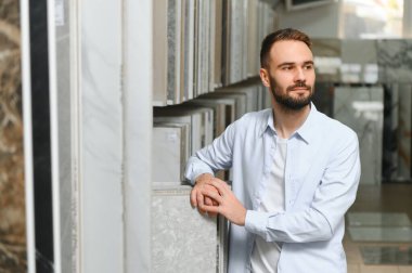 Adam ev banyosu için seramik fayans ve kap kacak seçiyor..