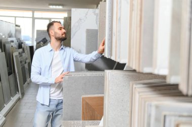 Adam ev banyosu için seramik fayans ve kap kacak seçiyor..