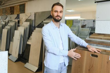 Erkek mağazadaki döşeme kaplamasını seçer.