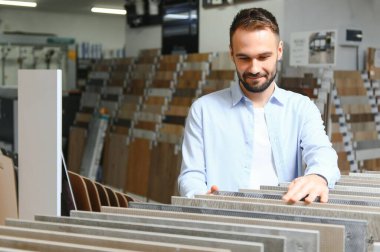 Markette fayans seçen genç bir adam.