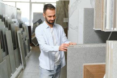 Adam ev banyosu için seramik fayans ve kap kacak seçiyor..