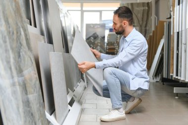 Adam ev banyosu için seramik fayans ve kap kacak seçiyor..