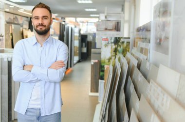 Markette fayans seçen genç bir adam.