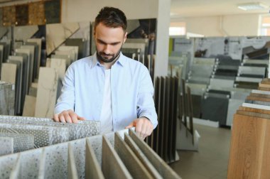 Adam ev banyosu için seramik fayans ve kap kacak seçiyor..