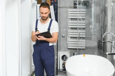 Tesisatçı dükkanında üniformalı bir tesisatçı..