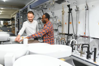 İnşaat pazarında banyolarına lavabo arayan Afrikalı bir adam..