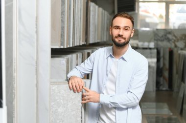 Markette fayans seçen genç bir adam.