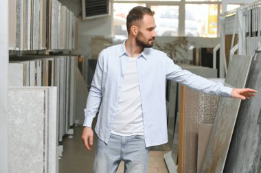 Markette fayans seçen genç bir adam.