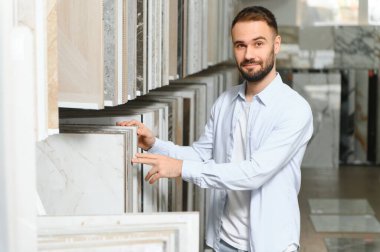 Markette fayans seçen genç bir adam.