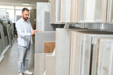 Adam ev banyosu için seramik fayans ve kap kacak seçiyor..