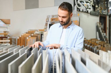 Markette fayans seçen genç bir adam