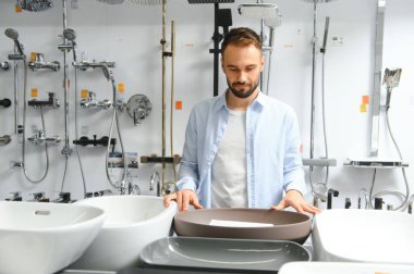 Adam evi için banyo lavabosu ve çatal bıçak seçiyor..