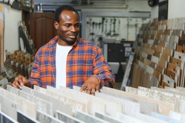 İnşaat pazarında fayans seçen Afrikalı Amerikalı bir adam..