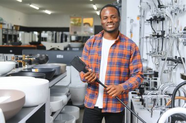 Büyük bir çeşme çeşmesi seçimi. Afrikalı Amerikalı bir adam hijyenik eşya dükkanından bir ürün seçiyor..