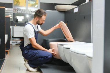 Tesisatçı dükkanında üniformalı bir tesisatçı..