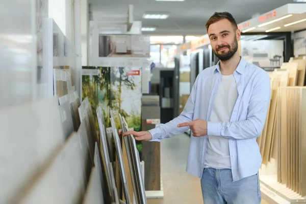 Markette fayans seçen genç bir adam.