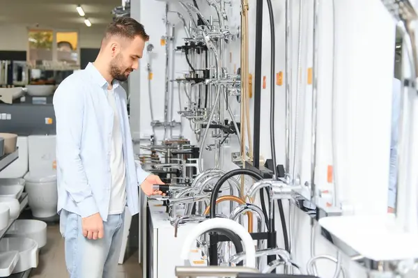 Büyük bir çeşme çeşmesi seçimi. Adam hijyenik eşya dükkanından ürün seçiyor..