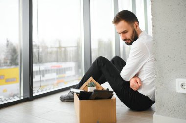 Kovulduktan sonra toplantı odasının dışında oturan üzgün iş adamı..