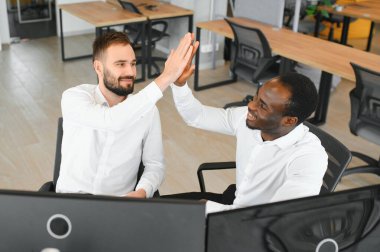 İki mutlu, başarılı, çeşitli tüccarları heyecanlandıran yatırımcı başarılı bir borsa anlaşması için beşlik çakıyor..