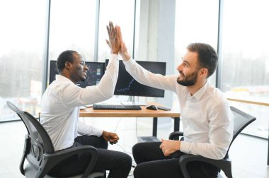 İki mutlu, başarılı, çeşitli tüccarları heyecanlandıran yatırımcı başarılı bir borsa anlaşması için beşlik çakıyor..