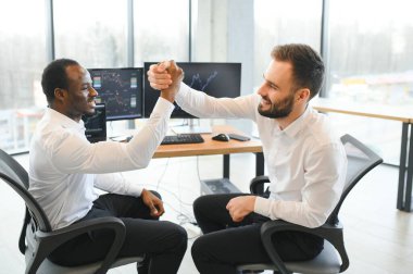 İki mutlu, başarılı, çeşitli tüccarları heyecanlandıran yatırımcı başarılı bir borsa anlaşması için beşlik çakıyor..