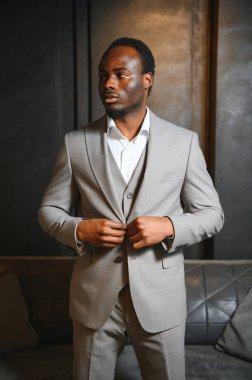 Koyu gri arka planda klasik takım elbiseli Afrikalı bir adam. Klasik giyim konsepti.