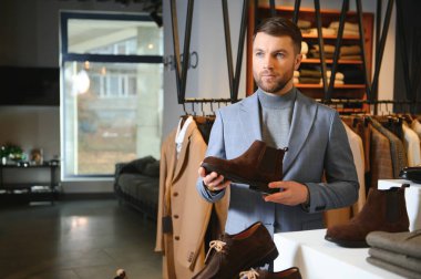 Ayakkabı mağazasında satın yakışıklı genç adam portresi.